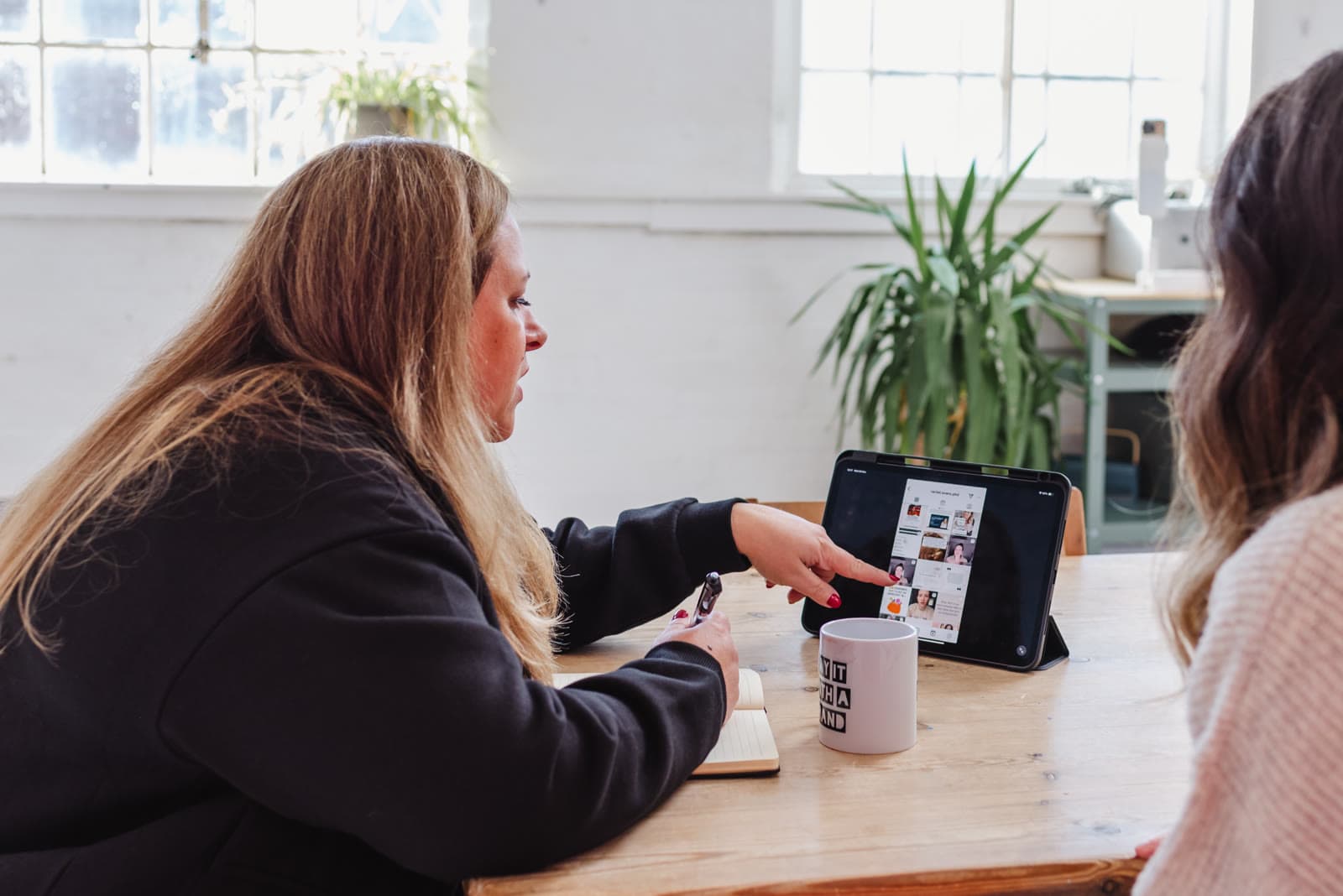 Jo listening to a client across a table, both smiling.